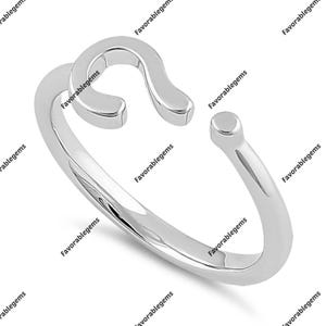 Op de afbeelding: Een zilveren ring met een eenvoudig, open ontwerp in de vorm van de letter "S".