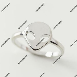 Könnte beinhalten: Ein silberner Ring mit einem Alienkopf-Design. Der Ring ist schlicht und minimalistisch.