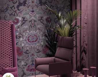 Op de afbeelding: Een paarse fauteuil met een hoge rugleuning staat voor een muur met een bloemig behangpatroon. Het behang heeft een herhalend ontwerp van roze, paarse en blauwe bloemen met ingewikkelde details. De kamer is modern ingericht met een paars tapijt en gordijnen.