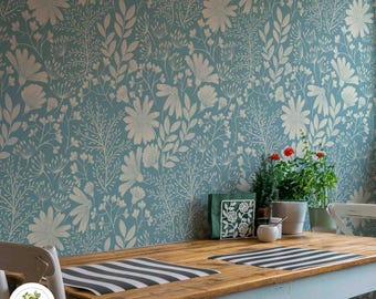 Könnte beinhalten: Ein Holztisch mit einem hellblauen floralen Tapetenhintergrund. Der Tisch hat zwei schwarz-weiße gestreifte Tischsets und einen weißen Serviettenhalter mit einem Blumendesign. Eine Topfpflanze mit roten Blüten steht auf dem Tisch.