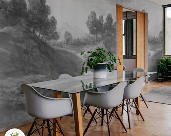 May include: A dining room with a glass table and six chairs. The wall behind the table is covered with a black and white landscape mural. The mural depicts a winding path through a forest with hills in the background.