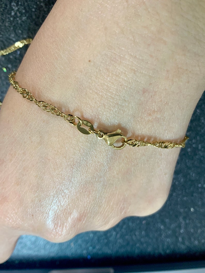 以下が含まれることがあります： ロブスタークラスプクロージャーが付いたゴールドチェーンブレスレット
