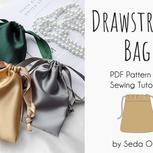 May include: Three drawstring bags made of satin fabric in green, gold, and gray. The bags are lying on a white surface. The image also includes a text overlay that reads "DRAWSTRING BAG PDF Pattern and Sewing Tutorial by Seda Ozel".