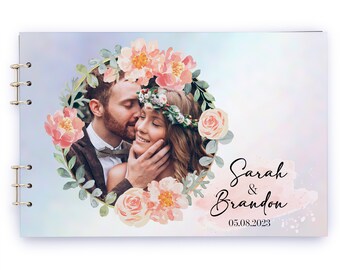 May include: A wedding guest book with a floral design and a photo of a couple in a gold frame. The text "Sarah & Brandon" and the date "05.08.2023" are printed on the cover.