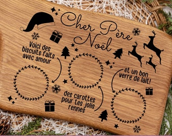 May include: Wooden Christmas serving board with a handle, engraved with holiday-themed text and illustrations. Features a Santa hat, reindeer, Christmas trees, and text that reads "Dear Santa". Includes spaces for cookies, carrots, and milk.