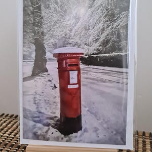Cassetta postale rossa in formato A6 con biglietto bianco innevato.