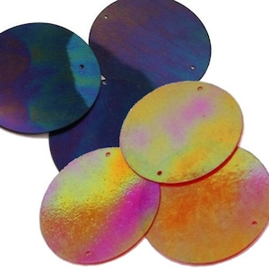 May include: Assortment of iridescent round sequins in various colours, including blue, pink, yellow, and orange. The sequins have a holographic finish and are perfect for crafting and decorating.
