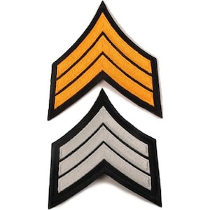 May include: Two embroidered chevron patches, one in gold and one in silver, with black edging. The patches are stacked on top of each other.
