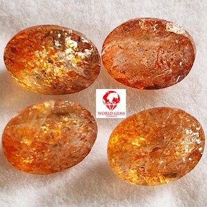 Könnte beinhalten: Vier ovale Sunstone-Edelsteine in rot-orange mit schimmerndem, irisierendem Finish.