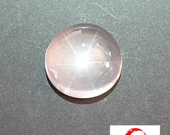 May include: A round, pale pink star-shaped gemstone with a four-pointed star in the centre.
