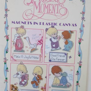 May include: A craft leaflet for making Precious Moments magnets. The leaflet shows four different designs featuring Precious Moments characters with sayings like "Make a Joyful Noise" and "Love is Kind".
