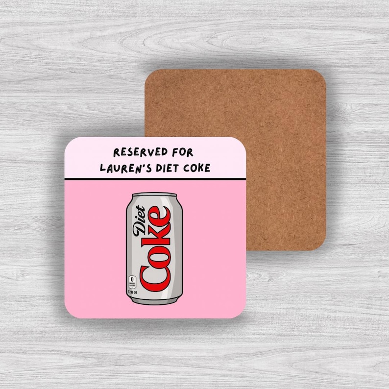 May include: A square coaster with a cork backing and a pink top surface. The design features a silver soda can with red text reading Diet Coke, and black text above the can that reads RESERVED FOR LAUREN'S DIET COKE on a light pink background.