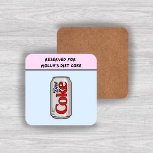 May include: A square coaster with a cork backing and a top surface featuring a light blue background and a pink header. The text reads RESERVED FOR MOLLY'S DIET COKE. Below the text is a graphic illustration of a silver Diet Coke soda can.