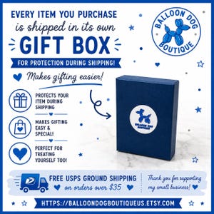 May include: A dark blue rectangular gift box featuring a white circular sticker with a blue balloon dog graphic and the text BALLOON DOG BOUTIQUE. The surrounding text includes EVERY ITEM YOU PURCHASE is shipped in its own GIFT BOX.