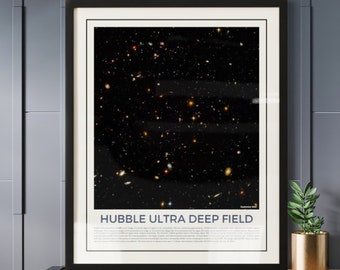 May include: A framed print of the Hubble Ultra Deep Field, a photograph of a small patch of space containing thousands of galaxies. The image is in black and white with a faint blue tint. The print is framed in a black frame with a white mat.