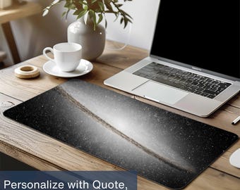 May include: A rectangular black and white mouse pad featuring a galaxy design. The mouse pad is on a wooden desk next to a laptop, a white coffee cup, and a vase with greenery. Text on the mouse pad says, "Personalize with Quote, Name, or Initials."