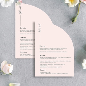 Może przedstawiać: Różowe i białe menu weselne z tekstem "let's eat" na górze. Menu zawiera opcje przystawek, dań głównych i deserów na przyjęcie weselne. Opcje przystawek obejmują sałatkę z owoców morza z krewetkami, kalmarami, scungilli i małżami z cytryną i oliwą z oliwek oraz świeże figi owinięte w prosciutto di parma. Dania główne obejmują pieczoną nogę angielskiej jagnięciny z rozmarynem, czosnkiem i ziemniakami dauphinoise oraz grillowanego łososia przyprawionego bułką tartą, czosnkiem, cytryną i masłem. Opcje deserów obejmują tort weselny i panna cotta waniliową z kompotem z owoców.