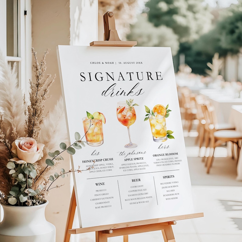 May include: A white sign on a wooden easel displays "SIGNATURE drinks" with three watercolor drink illustrations. The sign lists drink names and ingredients, including Honeycrisp Crush, Apple Spritz, and Orange Blossom.