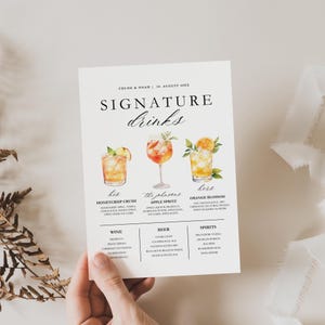 May include: A white paper drink menu with the text "SIGNATURE drinks". The menu features watercolor illustrations of three cocktails: Honeycrisp Crush, Apple Spritz, and Orange Blossom. Below are lists of wine, beer, and spirits.