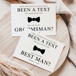 May include: Two white cards with black text and a black bow tie graphic. The top card says 'James, this obviously could have been a text (she made me do this). Will you be my groomsman?' The bottom card says 'James, this obviously could have been a text (she made me do this). Will you be my best man? March 21, 20XX'.