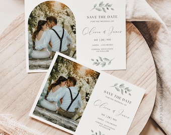 May include: Save the date card with a photo of a couple sitting on a wooden bench. The card is white with green leaves and the text "Save the Date for the wedding of Olivia & James" and "Sat | 28 | May Aspen Colorado Formal Invitation to Follow".