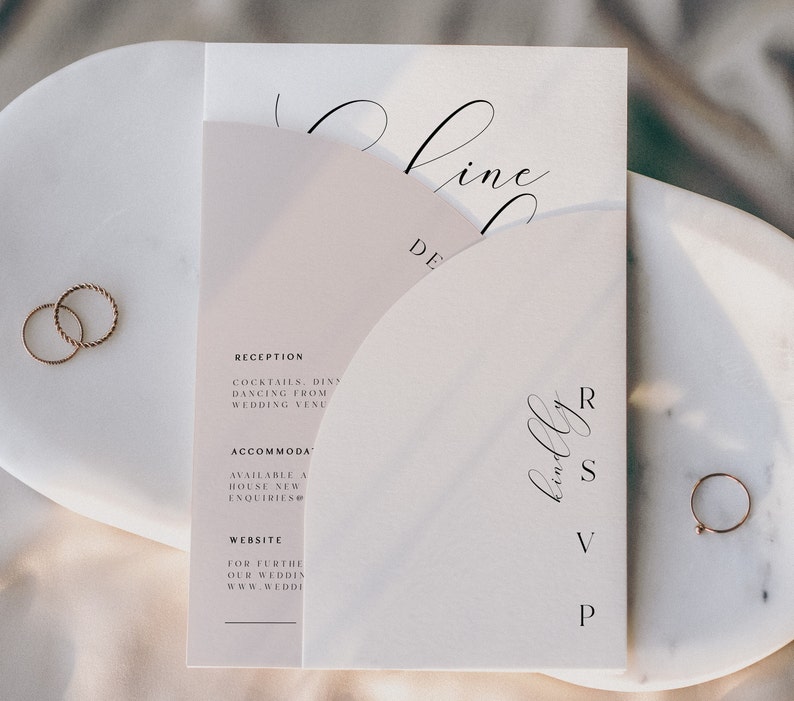 May include: A white wedding invitation with a pink half-circle design. The invitation includes the text "Reception", "Cocktails, Dinner", "Dancing from Wedding Venue", "Accommodation", "Available at House New Enquiries", "Website", "For further details on our wedding visit www.wedding.com", and "RSVP".