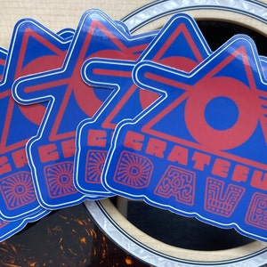 May include: Four blue and red stickers with the text "GRATEFUL DEAD" in a stylized font. The stickers are in the shape of a triangle with a circle inside.