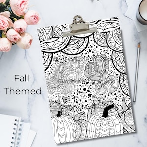 May include: A black and white clipboard with a fall-themed design featuring pumpkins and intricate patterns. The words "Fall Themed" are printed on the left side. The clipboard has a silver clip at the top.