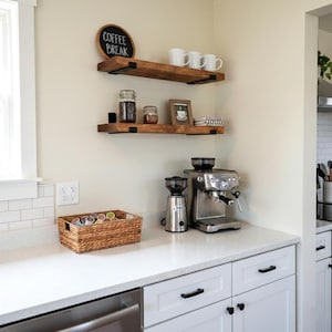 Peut inclure: Une sc&egrave;ne de cuisine avec un coin caf&eacute;. Deux &eacute;tag&egrave;res en bois accueillent des tasses, des bocaux et une photo encadr&eacute;e. Une cafeti&egrave;re, un moulin et un panier en osier sont sur le comptoir. Une ardoise indique "Coffee Break".