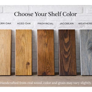 Wood stain color chart for rustic floating shelves featuring five finishes: Modern Oak, Aged Oak, Provincial, Jacobean, and Weathered Gray. Handcrafted solid wood samples displayed vertically against a white brick background to show natural grain and texture.