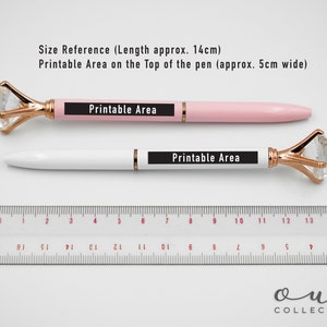 Puede incluir: Dos bol&iacute;grafos, uno rosa y otro blanco, con tapas de cristal en forma de diamante y detalles dorados. Los bol&iacute;grafos miden aproximadamente 14 cm de largo, con un &aacute;rea imprimible. Una regla est&aacute; colocada debajo. Texto en los bol&iacute;grafos: "Printable Area".
