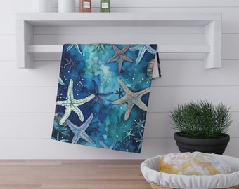 Puede incluir: Una toalla de cocina azul con un diseño de acuarela de estrellas de mar blancas sobre un fondo azul.