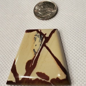 Beautiful Owyhee Jasper cabochon. Red streamers on a cream background.