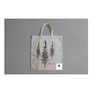 May include: A white tote bag with black line drawings of three fireweed plants. The word "Fireweed" is written in pink cursive below the plants.