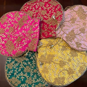 May include: Five round, fabric drawstring pouches with gold embroidery and pearl accents. The pouches are in shades of pink, yellow, green, and red.