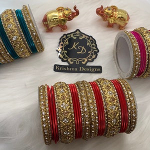 May include: Three sets of bangles, each with a different color scheme. The first set is teal and gold, the second is pink and gold, and the third is red and gold. Each set is adorned with rhinestones and intricate designs.
