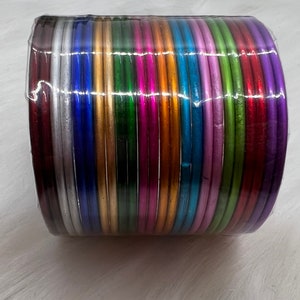 May include: A stack of colorful metal bangles in various shades of silver, gold, green, blue, purple, and red.