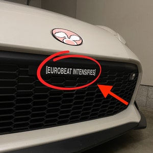 May include: White car with a black grill and a pink bunny logo. The text "[EUROBEAT INTENSIFIES]" is on the grill.