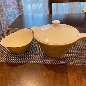 以下が含まれることがあります： ふた付きの黄色いセラミックボウル2個セット。ふた付きのボウルは内側が白で外側がテクスチャ加工されています。小さいボウルはシンプルなデザインです。