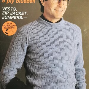May include: A blue knitted sweater with a cable knit pattern. The sweater is styled on a man wearing glasses. The text on the image reads "HIM in Patons 5 ply bluebell VESTS, ZIP JACKET, JUMPERS:- EASY TO FOLLOW PATTERNS STYLISH LIGHTWEIGHT CLASSICS HE WILL WANT TO WEAR FOR YEARS TO COME."
