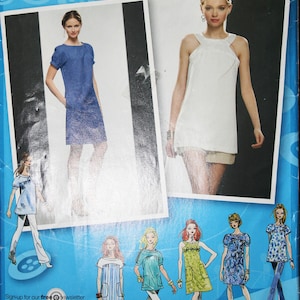 May include: A sewing pattern package with images of dresses and the text "2922". The package includes the text "Project Runway" and "simplicity.com". The package also includes the text "Sign-up for our free newsletter today at simplicity.com".