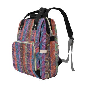 May include: A backpack featuring a vertical striped pattern in vibrant shades of orange, purple, blue, and green with a detailed leaf print. The bag includes black top handles, adjustable black shoulder straps, and a front zippered pocket with gold hardware.