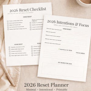 May include: Two white paper planners titled "2026 Reset Checklist" and "2026 Intentions & Focus" with text and checkboxes. The bottom of the image reads "2026 Reset Planner" with the words "Minimal, Intentional, Printable". A pen rests on the surface.