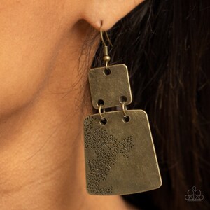 May include: Brass earrings with a square design. The earrings have a textured pattern and are a warm gold color.