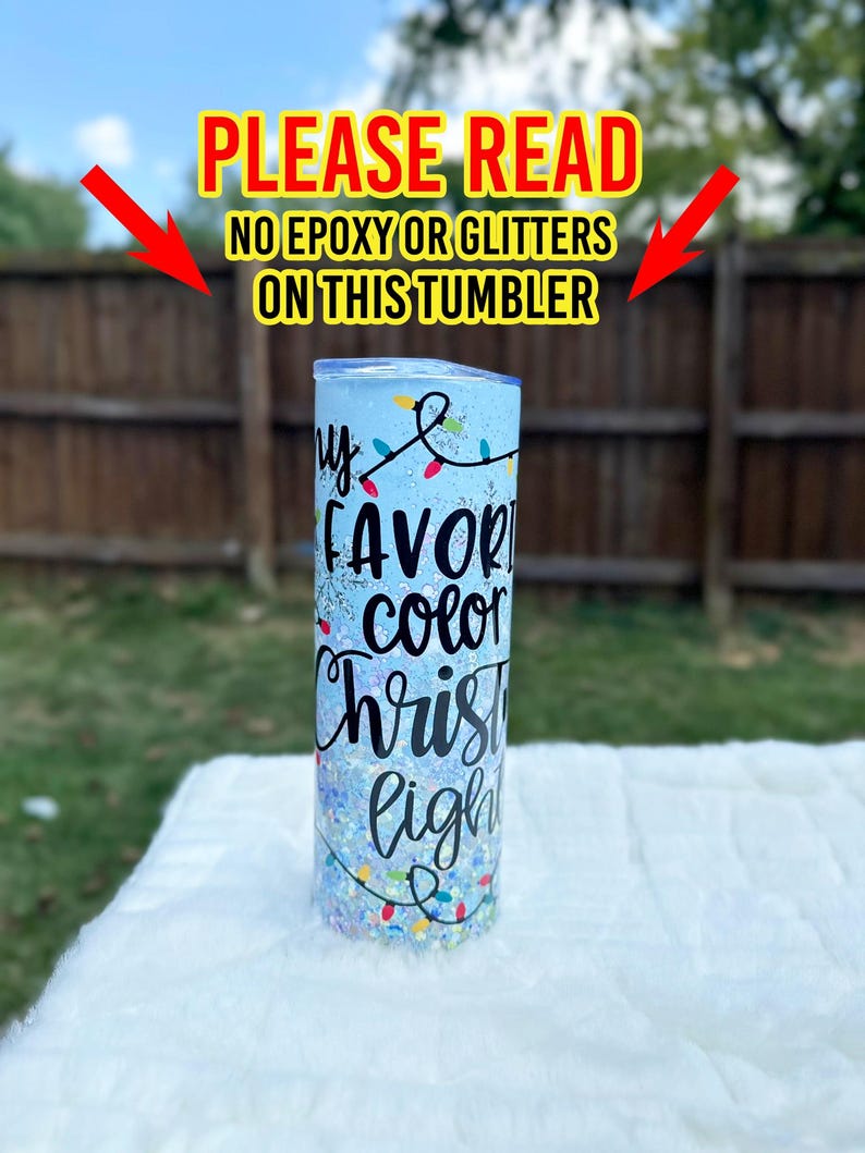 May include: A blue tumbler with glitter and a white design that says "My favorite color Christmas lights".