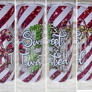 May include: A skinny tumbler with a festive design. The tumbler features a red and white striped pattern with a candy cane and bow graphic. Text on the tumbler reads "So Sweet but Twisted."