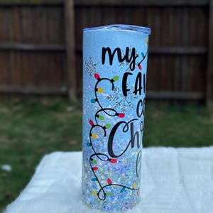 May include: A blue glitter tumbler with a white snowflake design and the text "my favorite Christmas lights" in black.