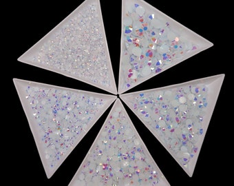 May include: Five white triangular trays filled with iridescent white rhinestones.