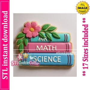 Puede incluir: Un cortador de galletas con forma de pila de tres libros con una flor rosa y hojas verdes encima. Los libros tienen las palabras ART, MATH y SCIENCE en letras mayúsculas blancas. El cortador presenta tonos turquesa, rosa y azul claro.