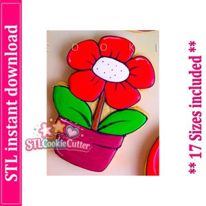 Puede incluir: Una galleta con forma de flor en una maceta, con una flor roja de centro blanco, un tallo marrón, dos hojas verdes y una maceta magenta. La imagen incluye el texto STL instant download y 17 Sizes included.